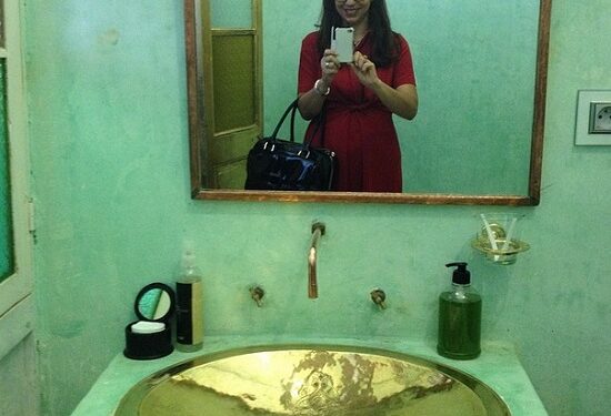 Amel Karboul se prend en photo dans la salle de bain d'une maison d'hôtes