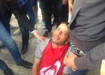 Lèvres agrafées, il s’allonge sur l’Avenue Bourguiba, recouvert du drapeau national