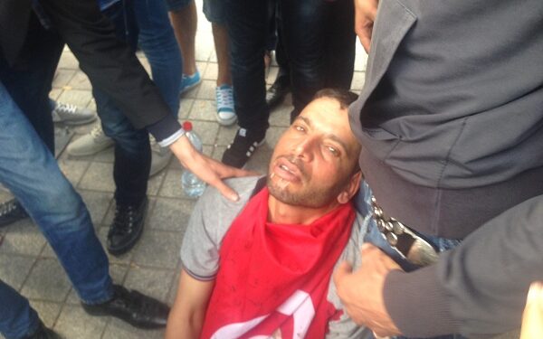 Lèvres agrafées, il s’allonge sur l’Avenue Bourguiba, recouvert du drapeau national