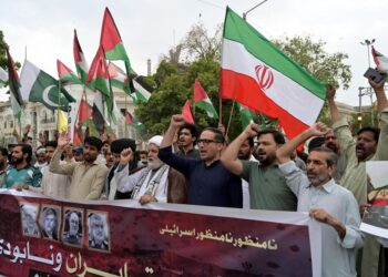 Des Pakistanais brandissent des drapeaux iraniens et scandent des slogans anti-israéliens lors d'une manifestation à Karachi le 15 juin 2025