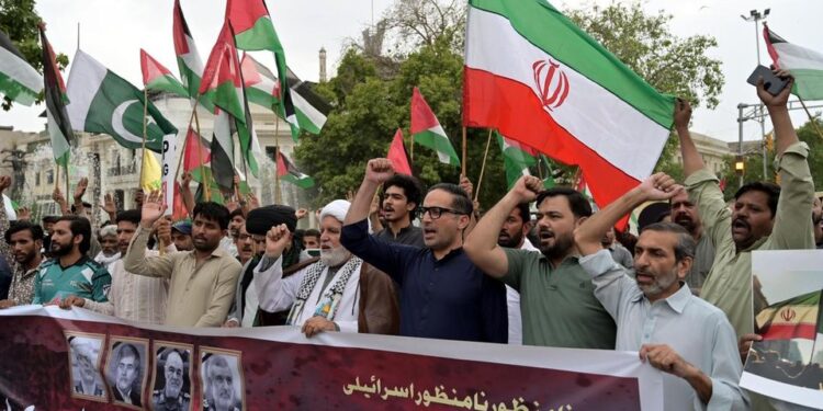 Des Pakistanais brandissent des drapeaux iraniens et scandent des slogans anti-israéliens lors d'une manifestation à Karachi le 15 juin 2025