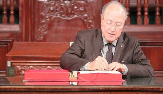 Mustapha Ben Jaafer signe un exemplaire de la Constitution lors de la dernière séance de l'ANC. Crédit photo : Page Facebook de l'ANC
